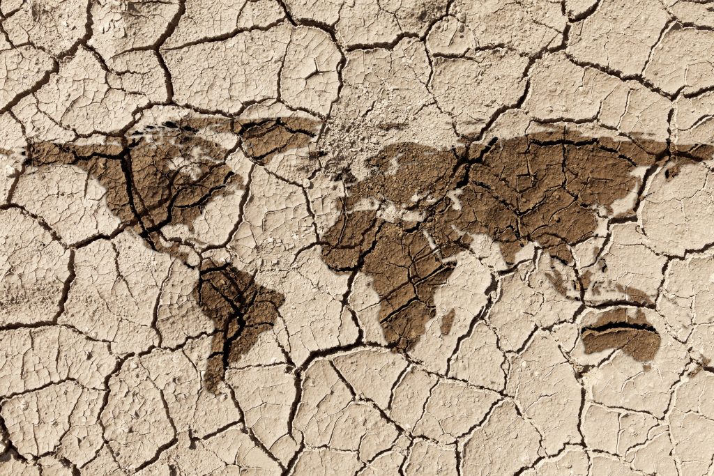 Map of the United States superimposed on caked cracked mud