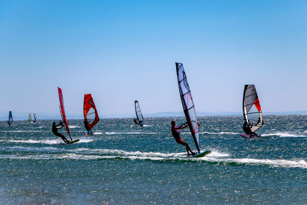 Windsurfers racing across the ocean